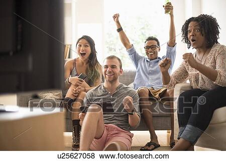 Stock Photo - Group of friends watching television. Fotosearch