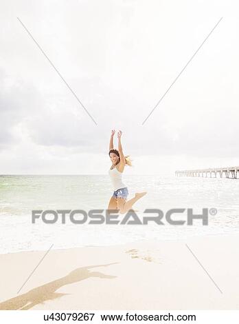 Stock Photo - Happy woman on beach. Fotosearch
