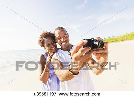 Man and woman photographing on beach View Large Photo Image Stock Photo - Man and woman photographing on beach. Fotosearch