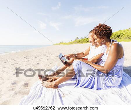Man and woman sitting on beach View Large Photo Image Stock Image - Man and woman sitting on beach. Fotosearch