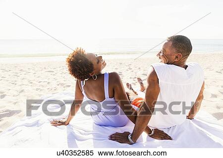 Man and woman sitting on beach View Large Photo Image Stock Photography - Man and woman sitting on beach. Fotosearch