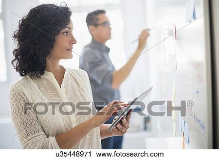 Man and woman working in office View Large Photo Image Stock Image - Man and woman working in office. Fotosearch