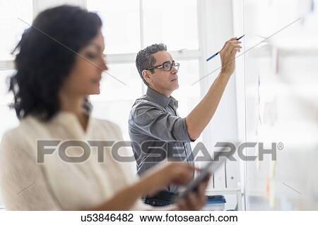 Man and woman working in office View Large Photo Image Stock Image - Man and woman working in office. Fotosearch