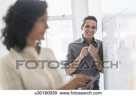 Stock Photo - Man and woman working in office. Fotosearch