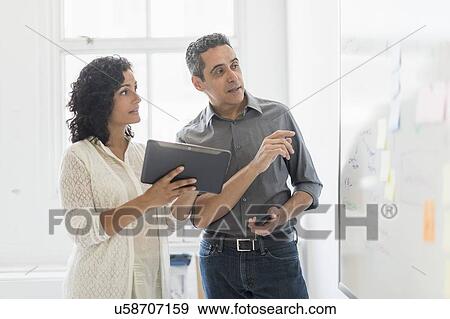 Stock Photo - Man and woman working together in office. Fotosearch