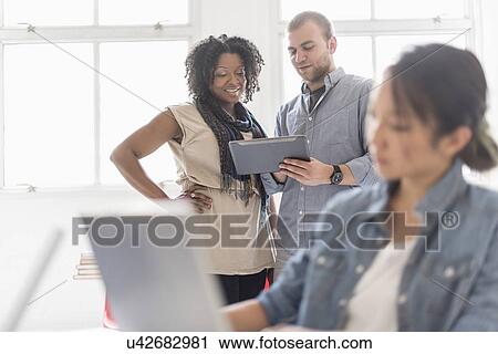 Stock Image - Man and women working in office. Fotosearch