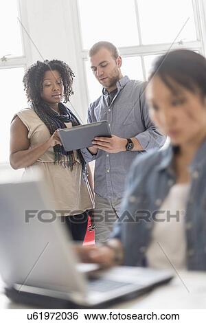 Man and women working in office View Large Photo Image Stock Photograph - Man and women working in office. Fotosearch