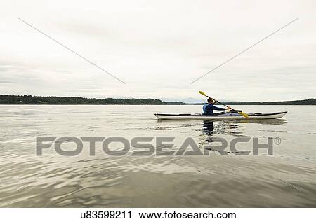 Man kayaking on lake View Large Photo Image Stock Image - Man kayaking on lake. Fotosearch