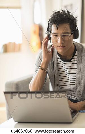 Stock Image - Man mixing music on laptop. Fotosearch
