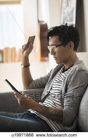 Man paying with credit card on tablet View Large Photo Image Stock Photo - Man paying with credit card on tablet. Fotosearch