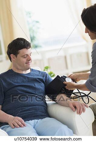 Man with down syndrome having blood pressure measured View Large Photo Image Stock Photo - Man with down syndrome having blood pressure measured. Fotosearch