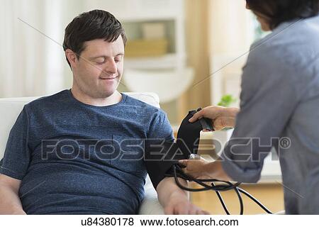 Man with down syndrome having blood pressure measured View Large Photo Image Stock Photo - Man with down syndrome having blood pressure measured. Fotosearch