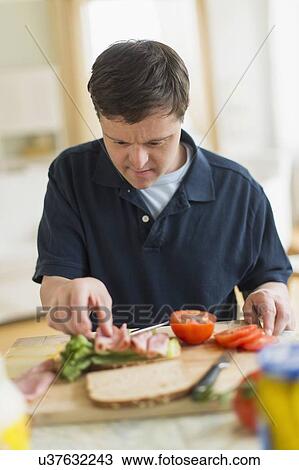 Man with down syndrome making sandwich View Large Photo Image Stock Image - Man with down syndrome making sandwich. Fotosearch
