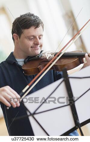 Stock Image - Man with down syndrome playing violin. Fotosearch