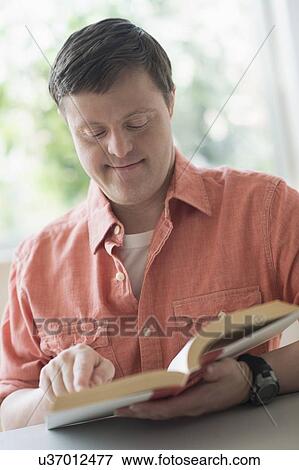 Man with down syndrome reading book View Large Photo Image Stock Photo - Man with down syndrome reading book. Fotosearch