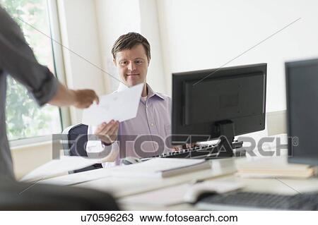 Man with down syndrome working in office View Large Photo Image Stock Image - Man with down syndrome working in office. Fotosearch