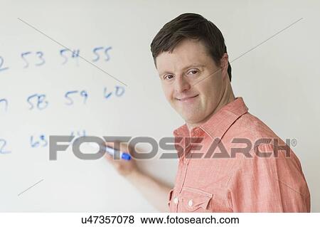 Man with down syndrome writing on whiteboard View Large Photo Image Stock Photo - Man with down syndrome writing on whiteboard. Fotosearch