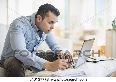 Man working in living room View Large Photo Image Stock Photo - Man working in living room. Fotosearch