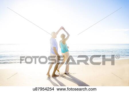 Picture - Mature couple dancing on beach. Fotosearch