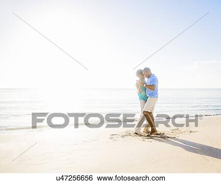 Stock Photograph - Mature couple dancing on beach. Fotosearch