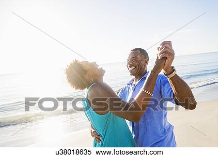 Stock Photography - Mature couple dancing on beach. Fotosearch