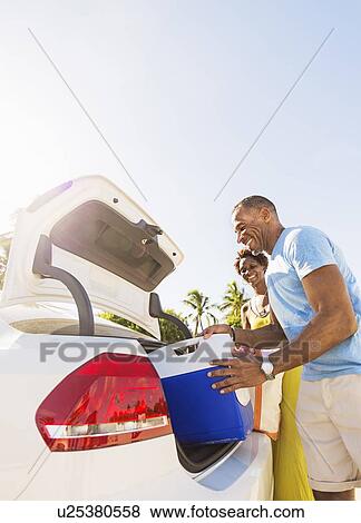 Stock Photo - Mature couple loading car trunk. Fotosearch