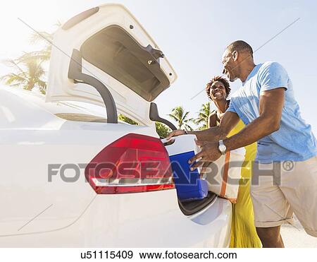 Stock Photo - Mature couple loading car trunk. Fotosearch