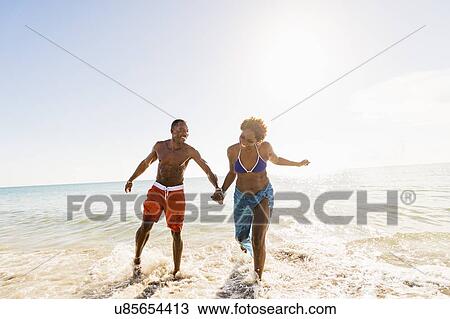 Mature couple running in sea View Large Photo Image Stock Image - Mature couple running in sea. Fotosearch