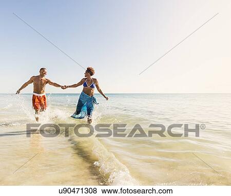 Mature couple running in sea View Large Photo Image Stock Photo - Mature couple running in sea. Fotosearch