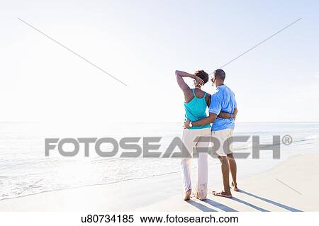 Stock Photography - Mature couple standing on beach. Fotosearch