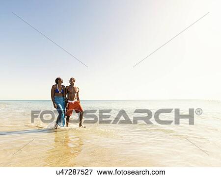 Stock Photo - Mature couple walking in sea. Fotosearch