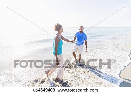 Mature couple walking on beach View Large Photo Image Stock Photo - Mature couple walking on beach. Fotosearch