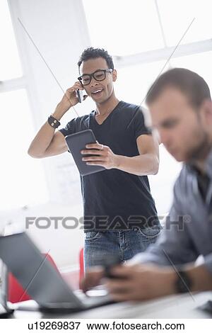 Stock Photo - Men working in office. Fotosearch