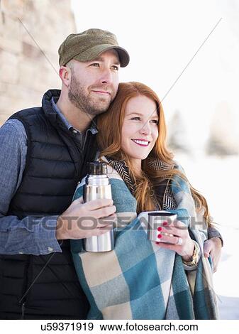 Mid adult couple having drink from vacuum flask, looking away View Large Photo Image Stock Photo - Mid adult couple having drink from vacuum flask, looking away. Fotosearch