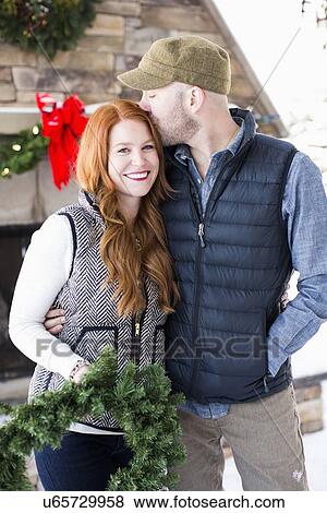 Mid adult couple holding wreath View Large Photo Image Stock Photo - Mid adult couple holding wreath. Fotosearch