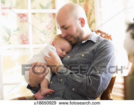 Mid adult man watching his son (2-5 months) sleeping View Large Photo Image Stock Photo - Mid adult man watching his son (2-5 months) sleeping. Fotosearch