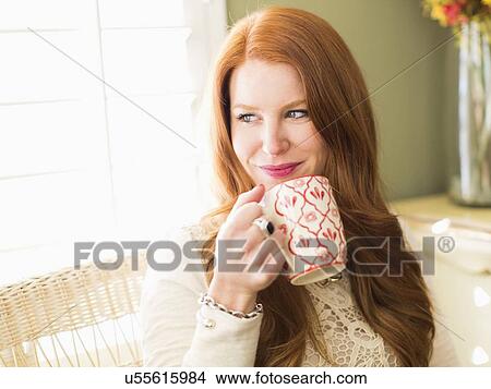 Mid adult woman drinking from coffee mug View Large Photo Image Picture - Mid adult woman drinking from coffee mug. Fotosearch