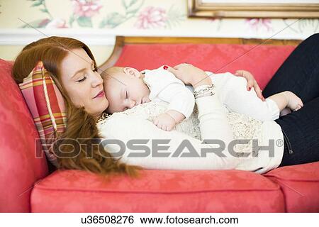 Mid adult woman napping with her baby boy (2-5 months) View Large Photo Image Stock Photograph - Mid adult woman napping with her baby boy (2-5 months). Fotosearch