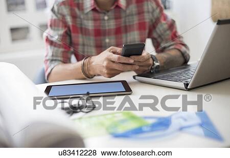 Mid section of man text messaging View Large Photo Image Stock Photo - Mid section of man text messaging. Fotosearch