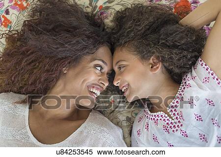 Mother and daughter (8-9) lying on bed View Large Photo Image Stock Photography - Mother and daughter (8-9) lying on bed. Fotosearch