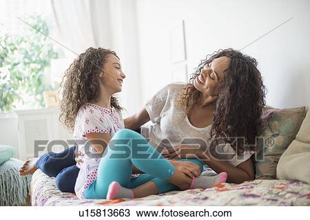 Mother and daughter (8-9) sitting on bed View Large Photo Image Stock Image - Mother and daughter (8-9) sitting on bed. Fotosearch
