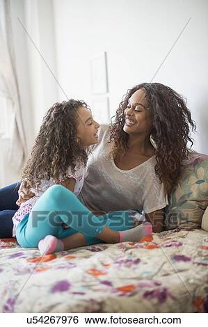 Mother and daughter (8-9) sitting on bed View Large Photo Image Stock Photograph - Mother and daughter (8-9) sitting on bed. Fotosearch