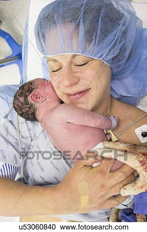 Stock Image - Mother holding newborn daughter. Fotosearch
