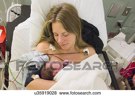 Stock Photo - Mother holding newborn daughter. Fotosearch