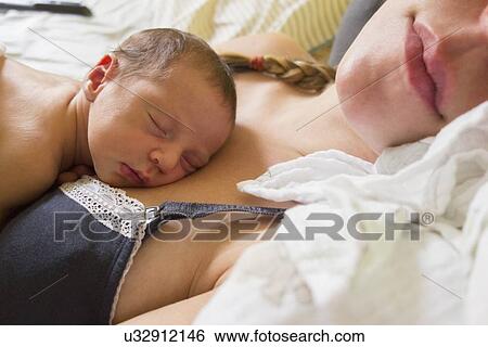 Stock Photograph - Mother holding newborn daughter. Fotosearch