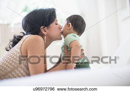 Mother kissing her baby son (6-11 months) View Large Photo Image Stock Photograph - Mother kissing her baby son (6-11 months). Fotosearch