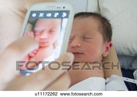 Mother photographing newborn daughter View Large Photo Image Stock Image - Mother photographing newborn daughter. Fotosearch