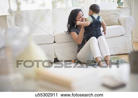Mother playing with her son (6-11 months) in living room View Large Photo Image Stock Image - Mother playing with her son (6-11 months) in living room. Fotosearch