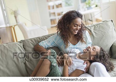 Mother tickling daughter (8-9) on sofa View Large Photo Image Stock Image - Mother tickling daughter (8-9) on sofa. Fotosearch