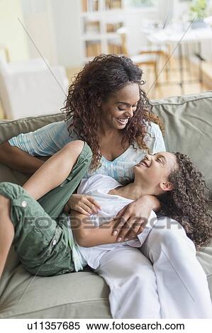 Mother tickling daughter (8-9) on sofa View Large Photo Image Stock Photography - Mother tickling daughter (8-9) on sofa. Fotosearch